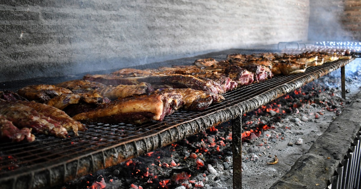 Meat is grilling over hot coals. — Clube Prime, Empório Família Rodrigues